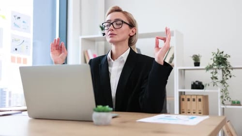Professional Woman Meditating at her Office Desk