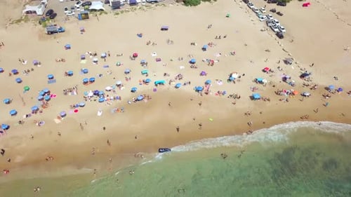 Tropical beach with colourful umbrellas and people enjoying the calm water