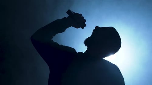 Silhouette of Bearded Man Singing with Microphone