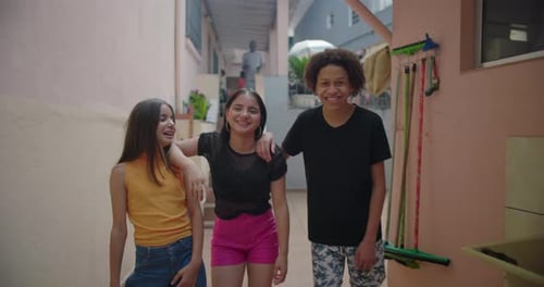 Three Friends Smiling in an Urban Courtyard