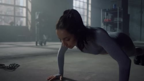 Athletic Woman Doing Pushups in a Gym