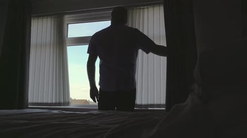 Man Opens Blinds and Window in Bedroom