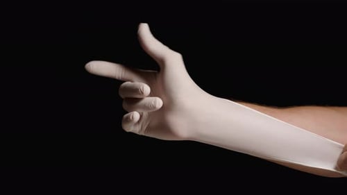 Arm Puts On White Protective Glove Close Up