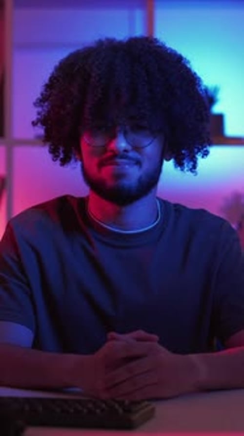 Young Adult with Curly Hair Sitting at Desk