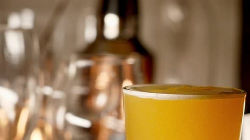 Close up of craft Beer being poured in to a pint glass, light background off center, with copy space
