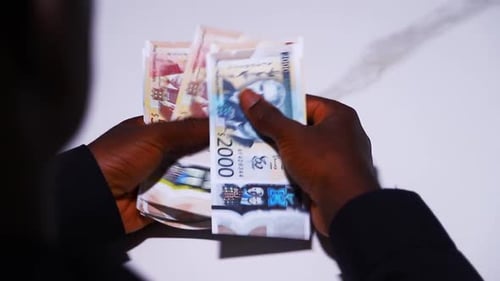 Man Counting Colorful Paper Currency in his Hands