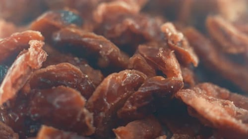 A macro close up shot of a pile of dry cranberry in a bawl on a rotating stand, slow motion, 4k