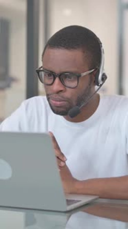 African American Man with Headset Talking with Customer in Call Center, vertical video