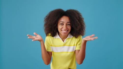 Fröhliche Afroamerikanerin springt auf und zeigt versautes Haar