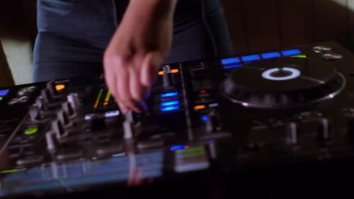 Person Using Professional DJ Mixing Board at Night