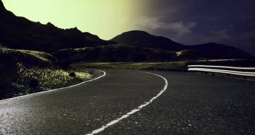 Curvy Road Winding Through Mountains at Night Under a Starry Sky