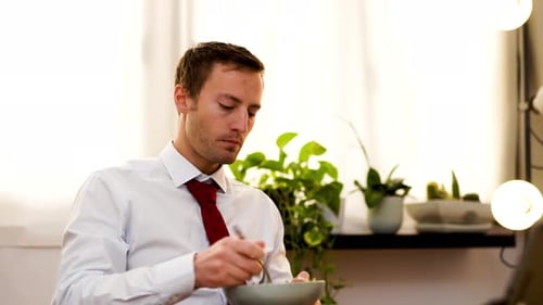 Young Man Eating Salad Indoors at Home
