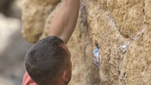 Ein Mann klettert auf eine Felswand