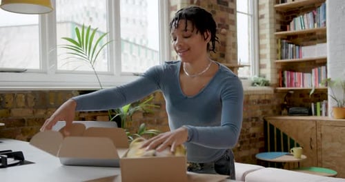 Woman Packing Scarf in Box at Home