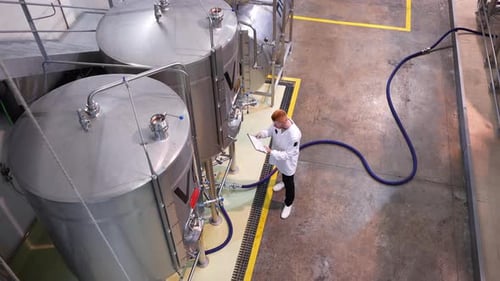 Technicien de brasserie inspectant les cuves de fermentation de la bière