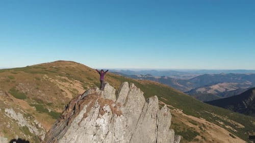 The Triumphant Hiker Reaches the Rocky Summit Absorbing the Majestic Mountain View with a Sense of