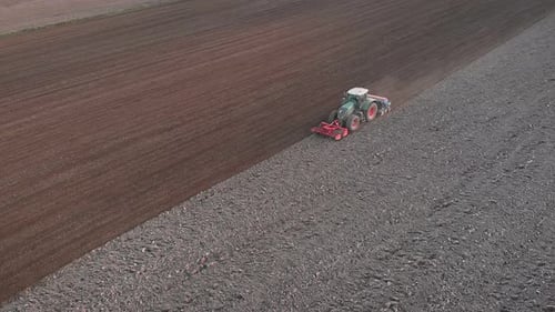 Tractor Plowing Farm Field From Aerial View