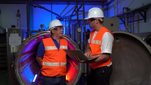 Factory Workers Discussing Machinery