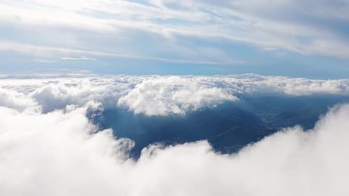 Aerial view of clouds covering mountains, capturing nature’s serene beauty from above