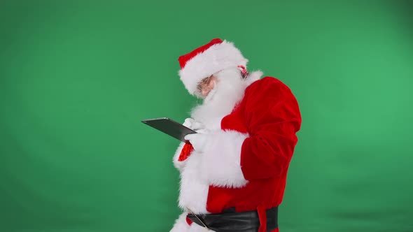 Santa Takes Notes on His Tablet with a Green Screen Backdrop, Holidays ...