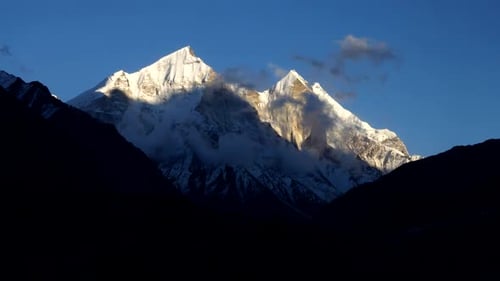 Time lapse from sunrise to sunset of clouds rolling and flowing over peaks of the Himalayan Range, U