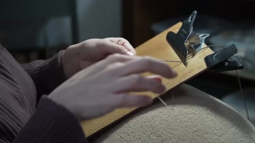 Woman Works with String on Wooden Frame