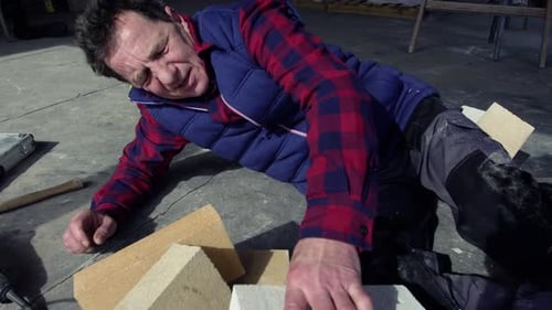 Injured Construction Worker Lying on the Ground in Pain
