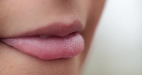 Macro close-up of young woman mouth biting lips