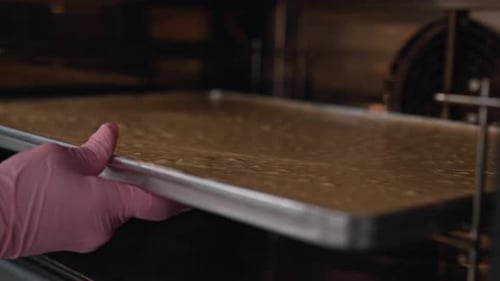 Baker Putting Baking Sheet into Oven