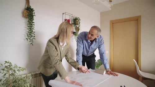 Professional Architects Collaborating on a Building Blueprint Project