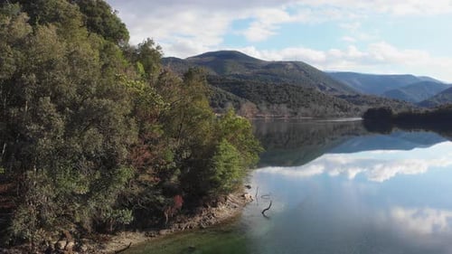Low altitude drone flight over Mountain lake sunny summer day panning left