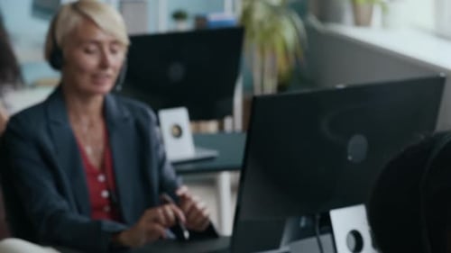Operators of Call Center Talking to Online Customers in front of Computers