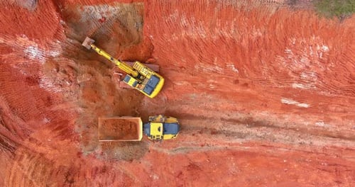 Excavator Filling Dump Truck with Red Dirt Aerial