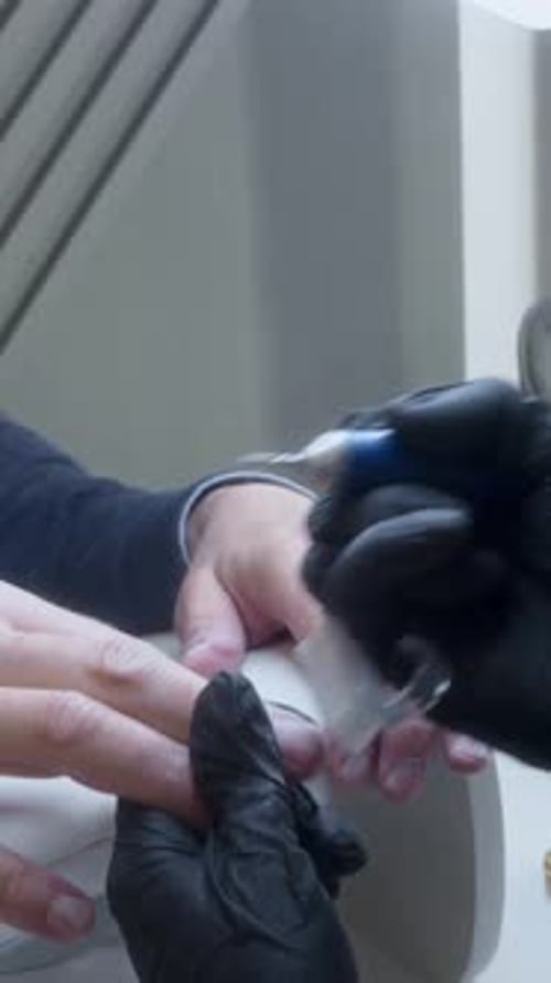 Mature Man Receives Manicure in Beauty Salon