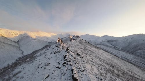 Aerial View of Majestic Snow Covered Mountains at Sunrise