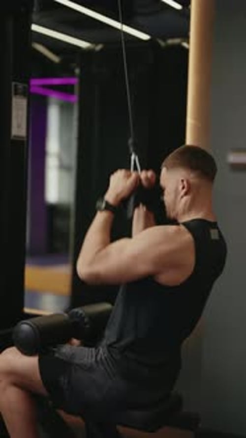 Young Man Performing Lat Pulldowns in a Modern Gym