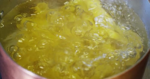 slow motion of Italian pasta typical that falls inside a full pot of boiling water to cook the Ita
