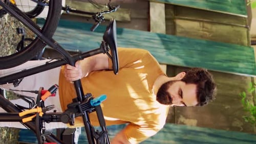 Vertical Video Man Moving Bicycle to Repairstand