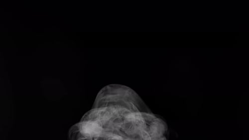 Wispy White Smoke Billowing Against Black Background