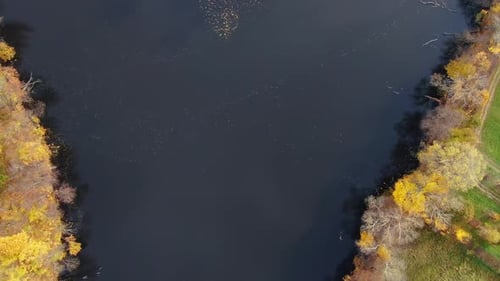 Aerial view of beautiful smooth green waters of a lake on a sunny autumn day. Bird's eye view of sce