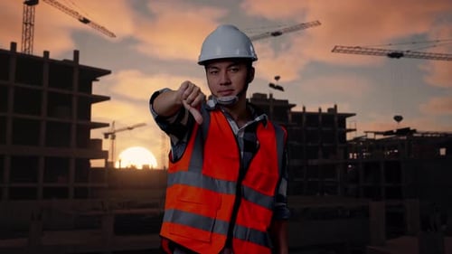 Asian Male Engineer Showing Thumbs Down Gesture And Shaking His Head At Building Site