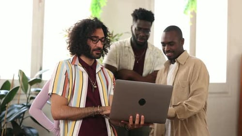 Young Adults Looking at Laptop Together in Workplace