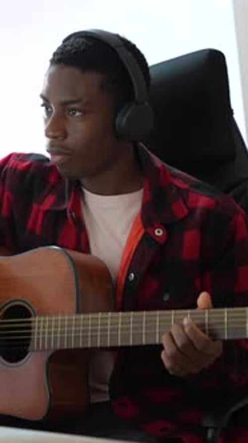 Young Man Plays Acoustic Guitar at Home