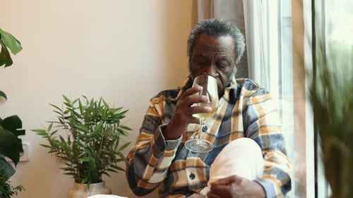 african old man drinks alcoholic wine sad depression