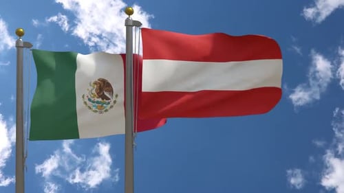 Mexico and Austria Flags Waving on Flagpoles Against Blue Sky