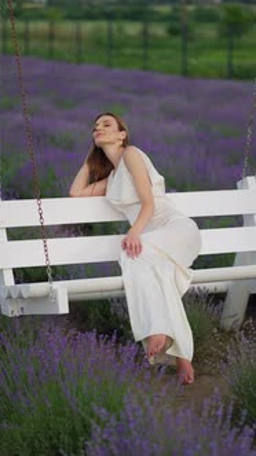 Portrait of a Happy Woman Sitting on a Swing and Smiling