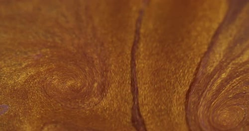 Swirling Liquid Gold and Bronze Paint Close Up