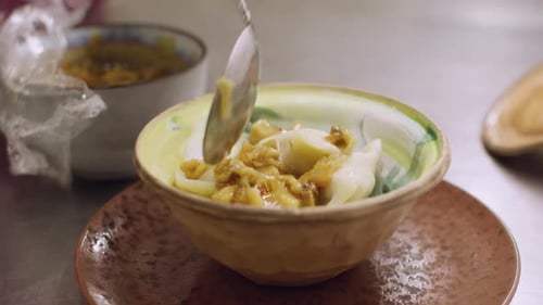 Dumplings Being Prepared in a Bowl with Toppings