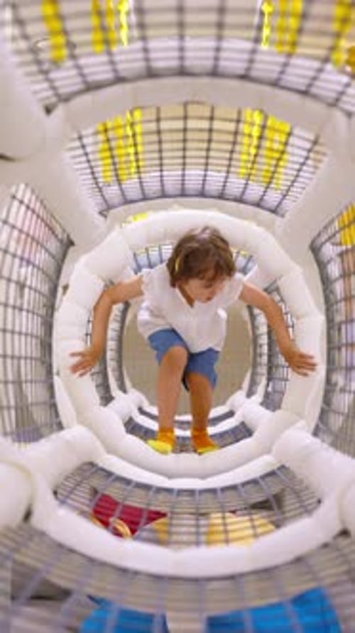 Little girl crawls through a tunnel