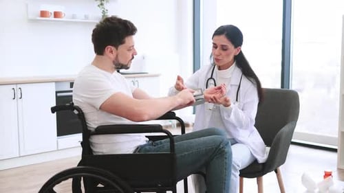 Doctor Checking Blood Pressure of Patient in Wheelchair